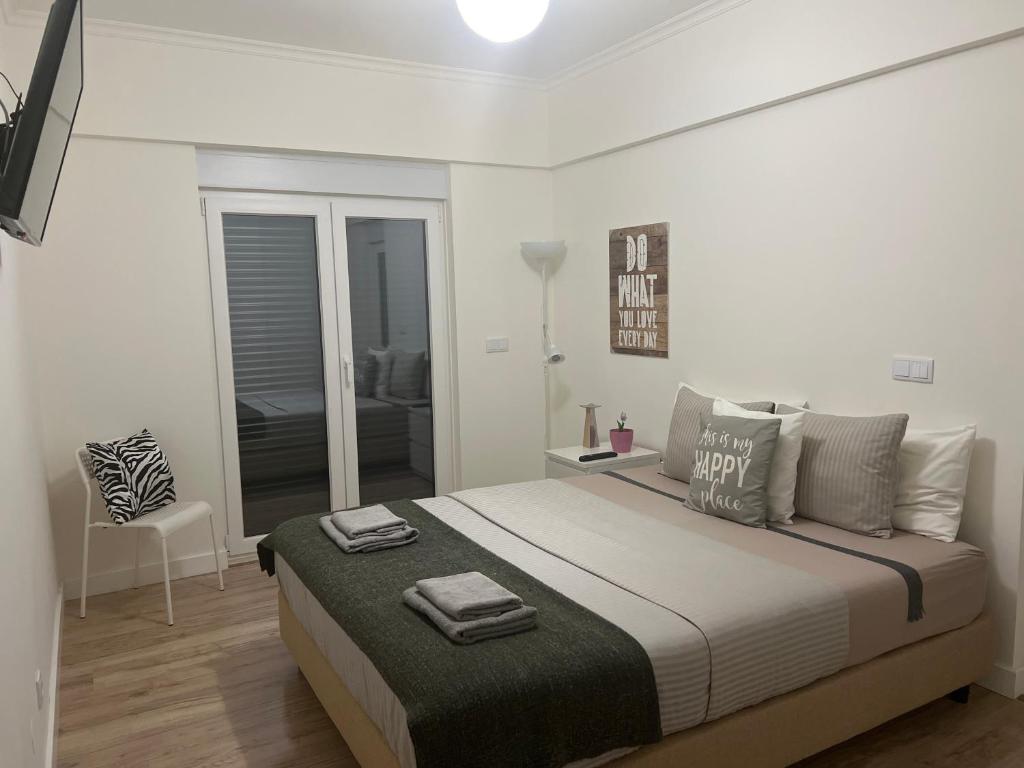 a white bedroom with a large bed and a chair at Modern Double Room with Private Balcony in Montijo