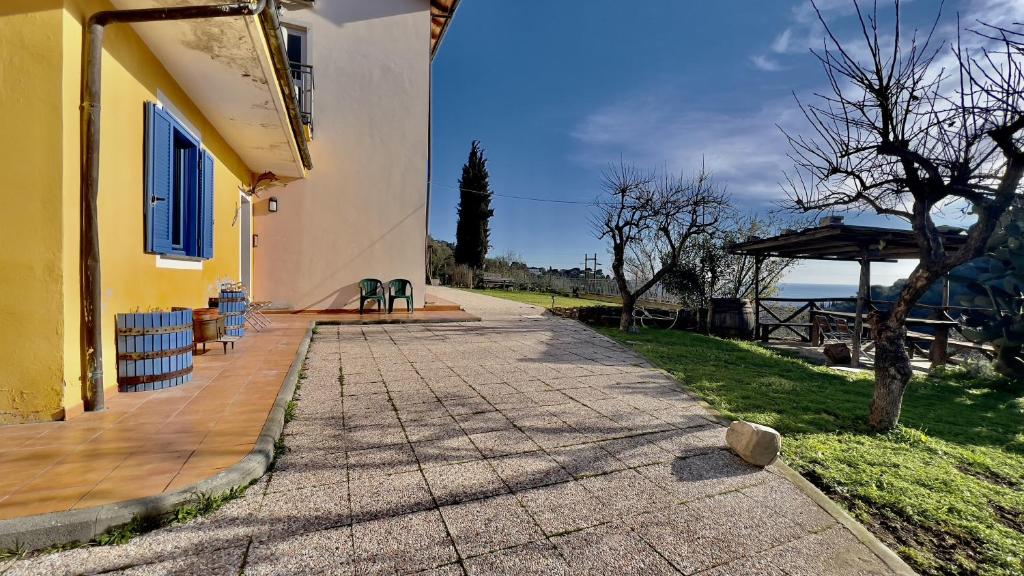 una passerella accanto a un edificio giallo con un albero di Ca' del Bosco ad Alassio