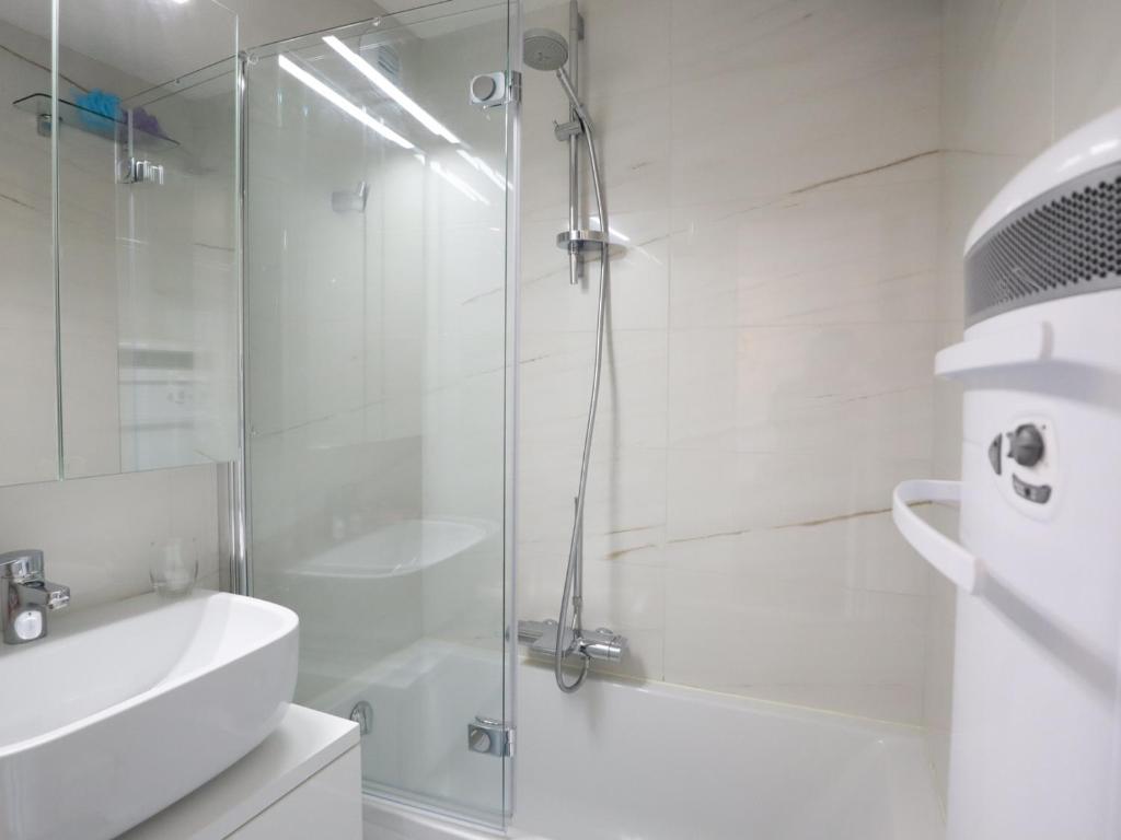 a white bathroom with a shower and a sink at Appartement Les Gets, 3 pièces, 4 personnes - FR-1-623-292 in Les Gets