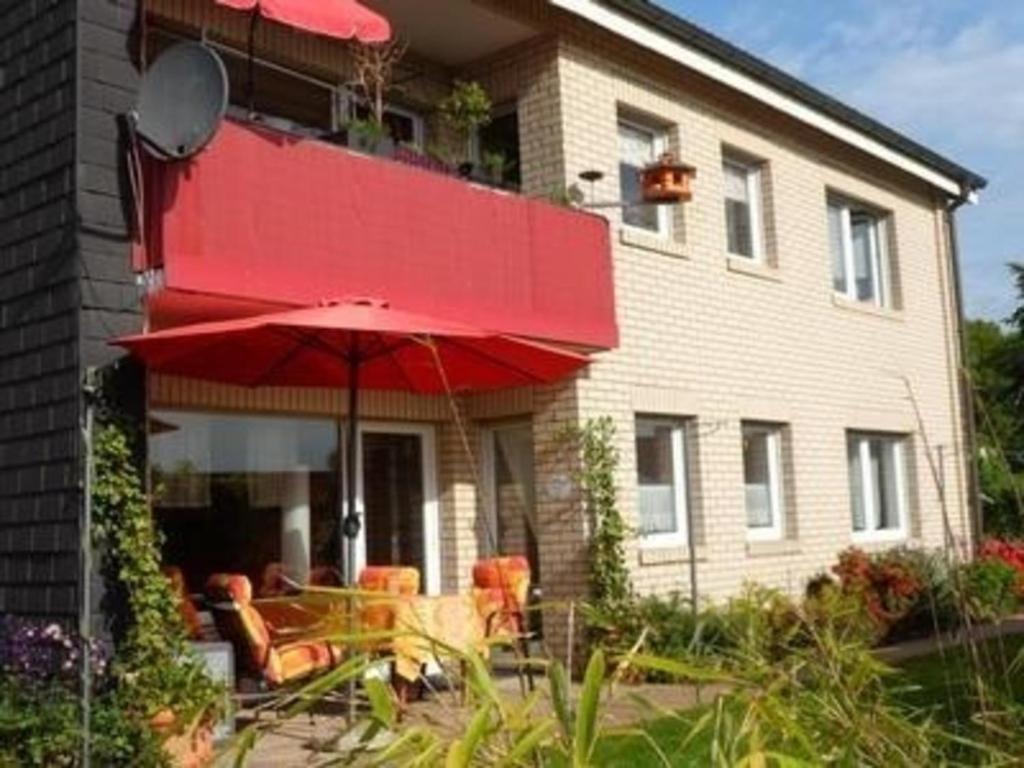 奧爾珀的住宿－Gemütliche Ferienwohnung in Eichhagen mit Grill, Terrasse und Garten，房屋前的红伞