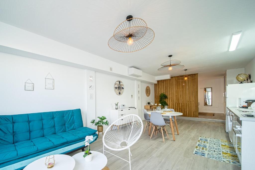 sala de estar con sofá azul y cocina en Apartamento Alisios Beach Puerto del Carmen, en Puerto del Carmen