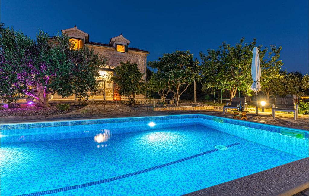 uma grande piscina em frente a uma casa em Amazing Home In Lozovac With Kitchen em Lozovac