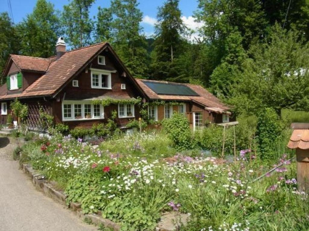 una casa con un jardín de flores delante de ella en Brandholz, en Ebnat