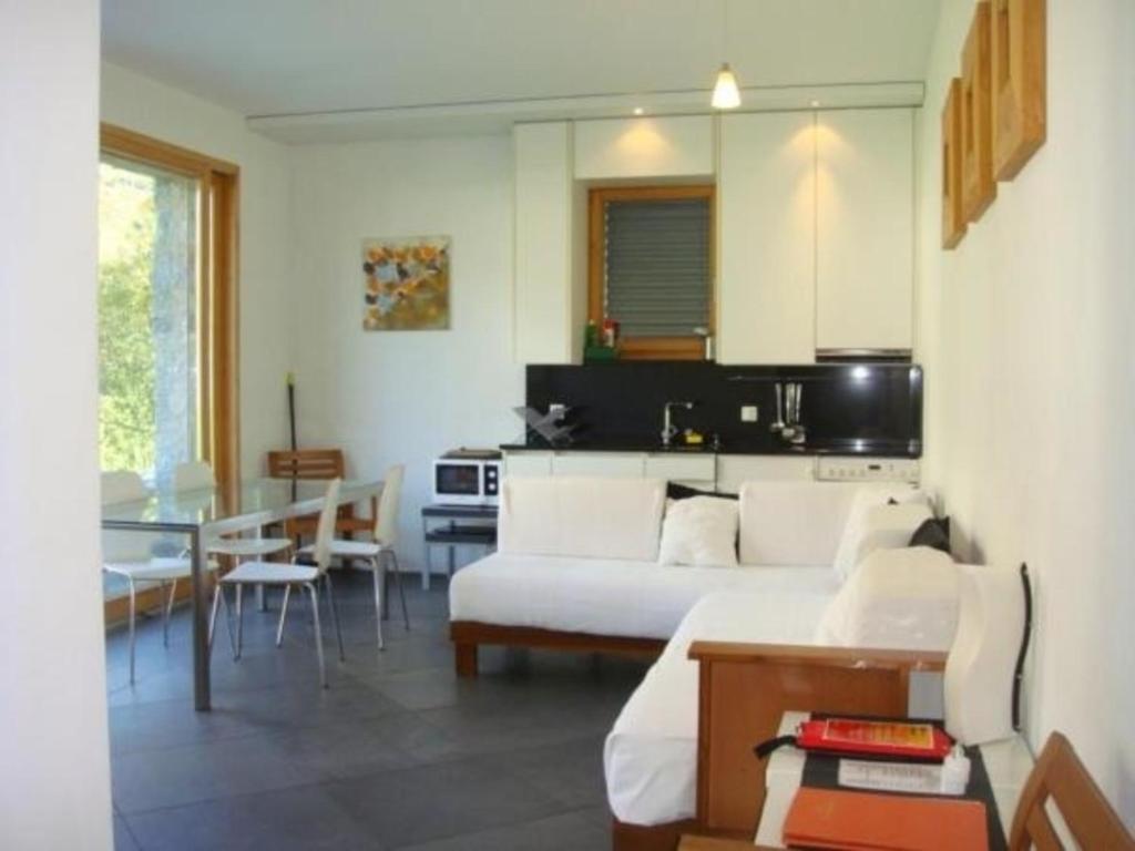 een woonkamer met een bed en een eetkamer bij La Montanella 7 in Maloja