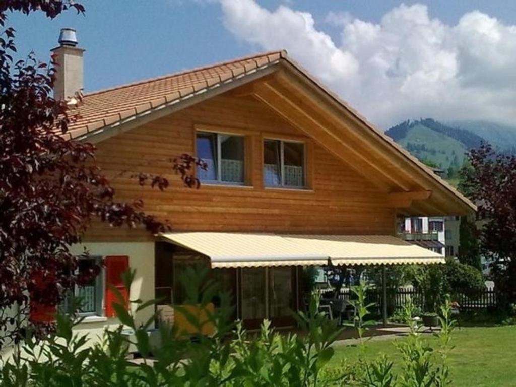 a wooden house with a white awning at Sunneggli in Aeschi bei Spiez