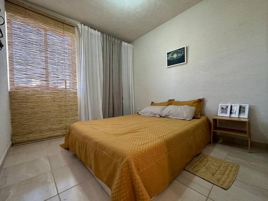 a bedroom with a bed and a large window at casa buu in San Miguel de Allende