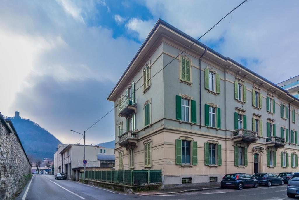 budynek z zielonymi okiennicami na ulicy w obiekcie Casa Magenta w Como