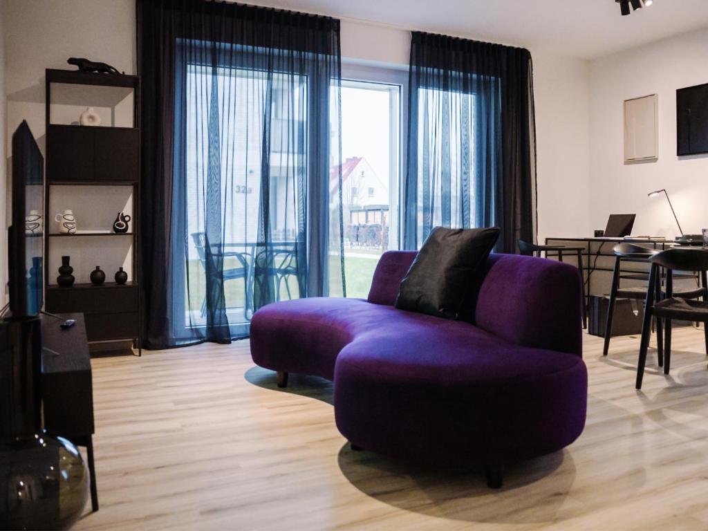 a living room with a purple couch and a table at Lio Suite Deluxe Apartment Küche Terrasse Parken Netflix in Lübbecke