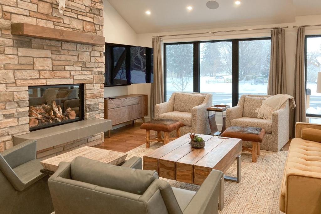 sala de estar con chimenea, sillas y mesa en Leisure Lodge Living, en Gunnison