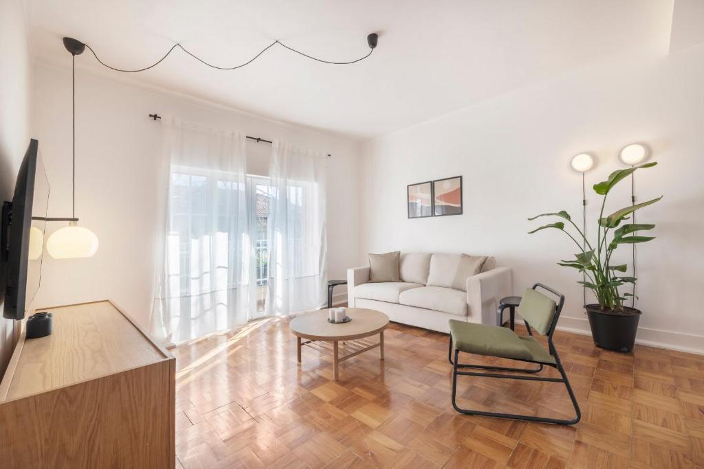 sala de estar con sofá blanco y mesa en Coral Apartment by Olala Homes, en Cascais