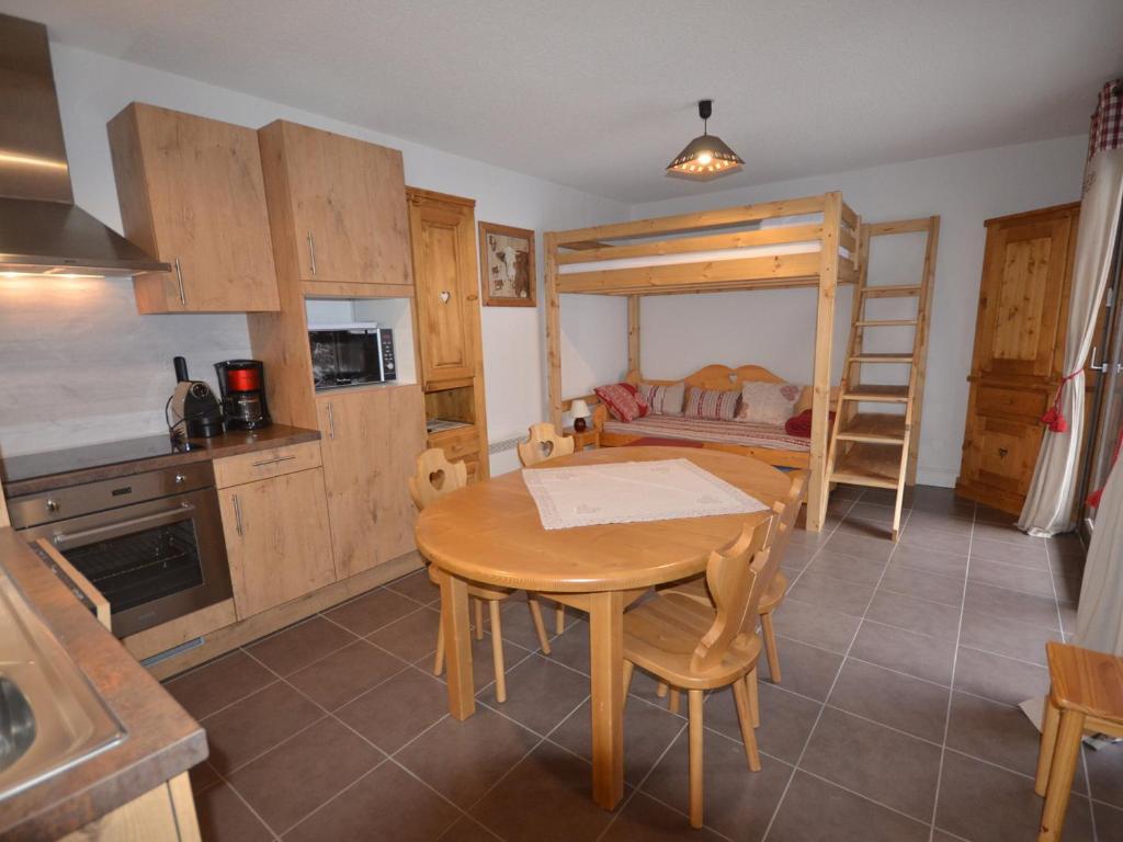 - une cuisine et une salle à manger avec une table et des lits superposés dans l'établissement Appartement au Centre des Gets, Proche Pistes et Commerces, Terrasse et Garage Inclus - FR-1-623-161, aux Gets