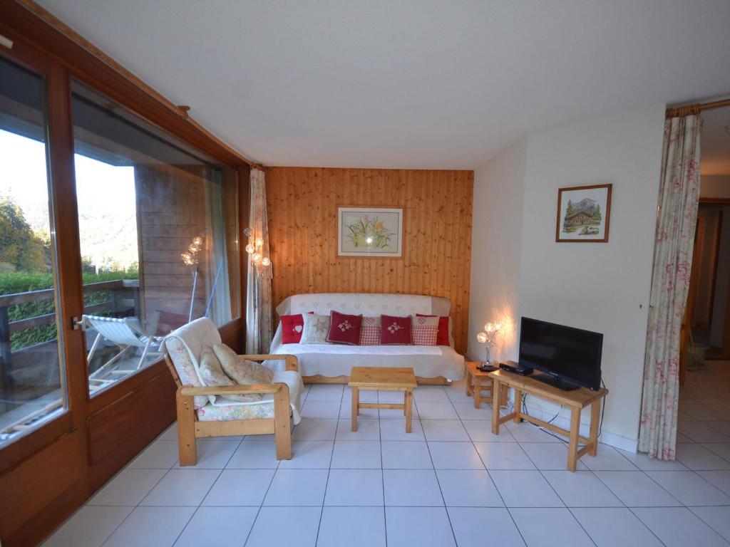 un salon avec un lit et une télévision dans l'établissement Appartement 3 étoiles aux Gets, skis aux pieds, balcon, parking et animaux acceptés - FR-1-623-125, aux Gets