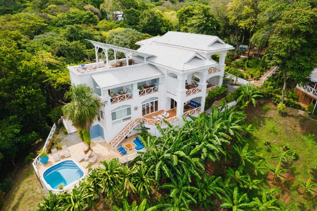 - une vue aérienne sur une maison blanche dotée d'une piscine dans l'établissement Blue Roatan Resort, à West Bay