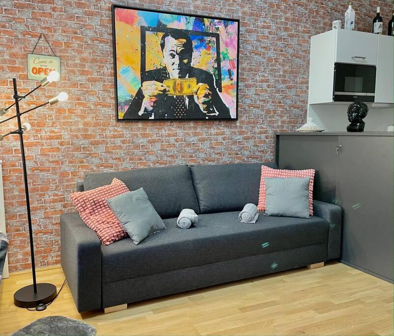 a couch in a living room with a brick wall at Premium Apartment with Terrace, A/C, FREE WiFi and NETFLIX in Vienna