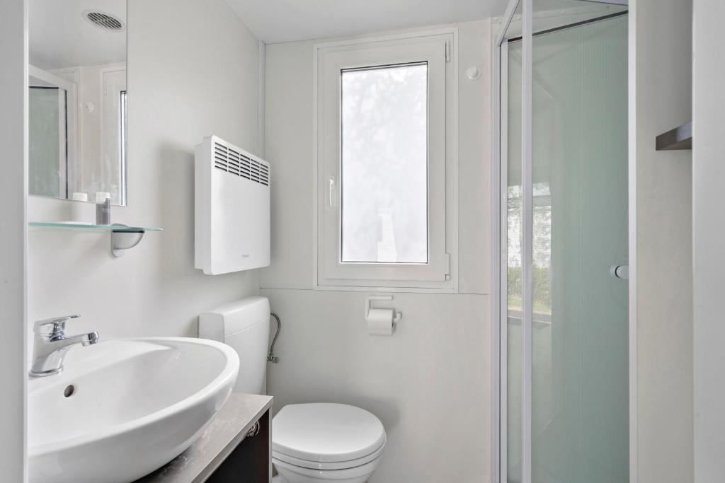 un bagno bianco con lavandino e WC di First Camp Hasmark Camping Resort & Cottages a Otterup