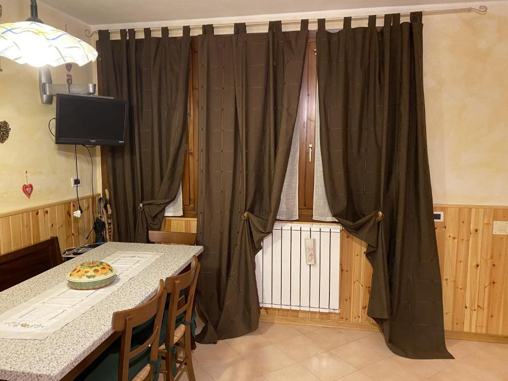 a dining room with a table and a curtain at Sulle piste da sci in Abetone