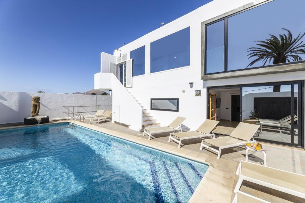 a villa with a swimming pool and a house at Villa Atlantico - Villasexperience in Arrecife