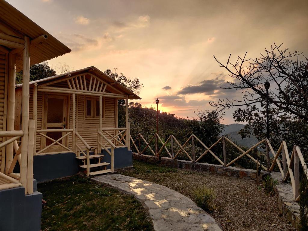 Cabaña de madera con puesta de sol en el fondo en Lacasa Luxury Stays, en Shogi