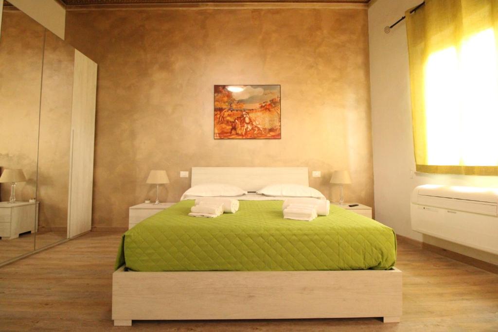 1 dormitorio con 1 cama con sábanas y almohadas verdes en Nora's House, en Siena