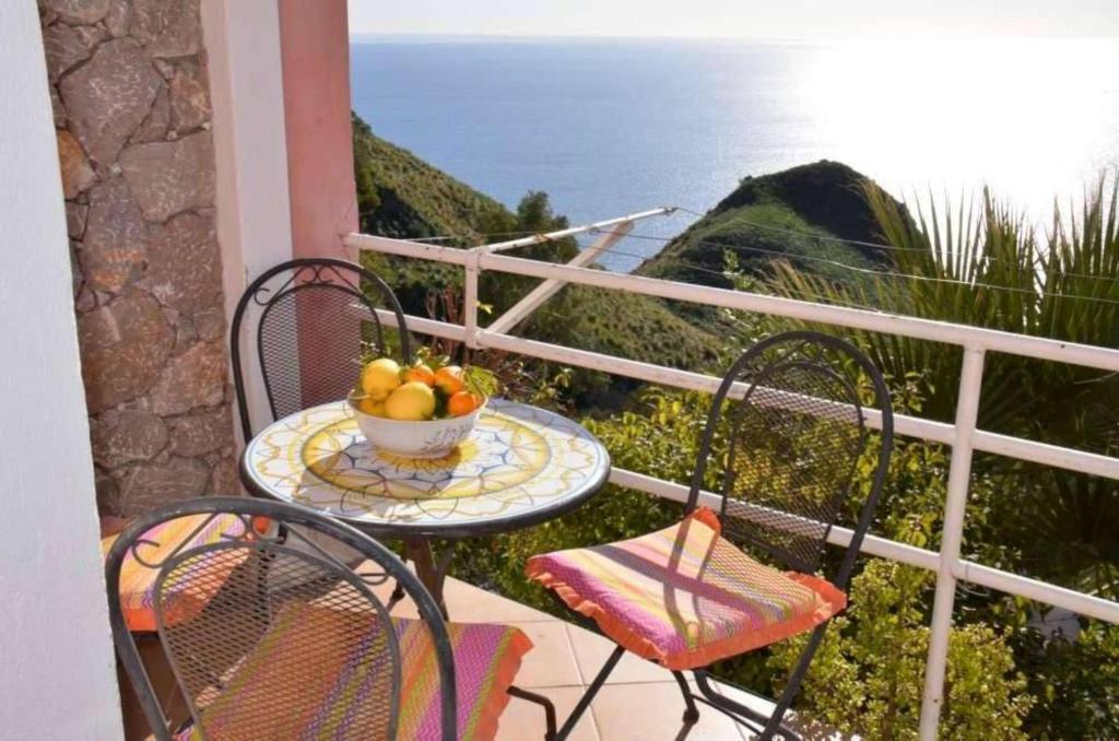 una mesa con un bol de fruta en el balcón en Villa kate, en Taormina