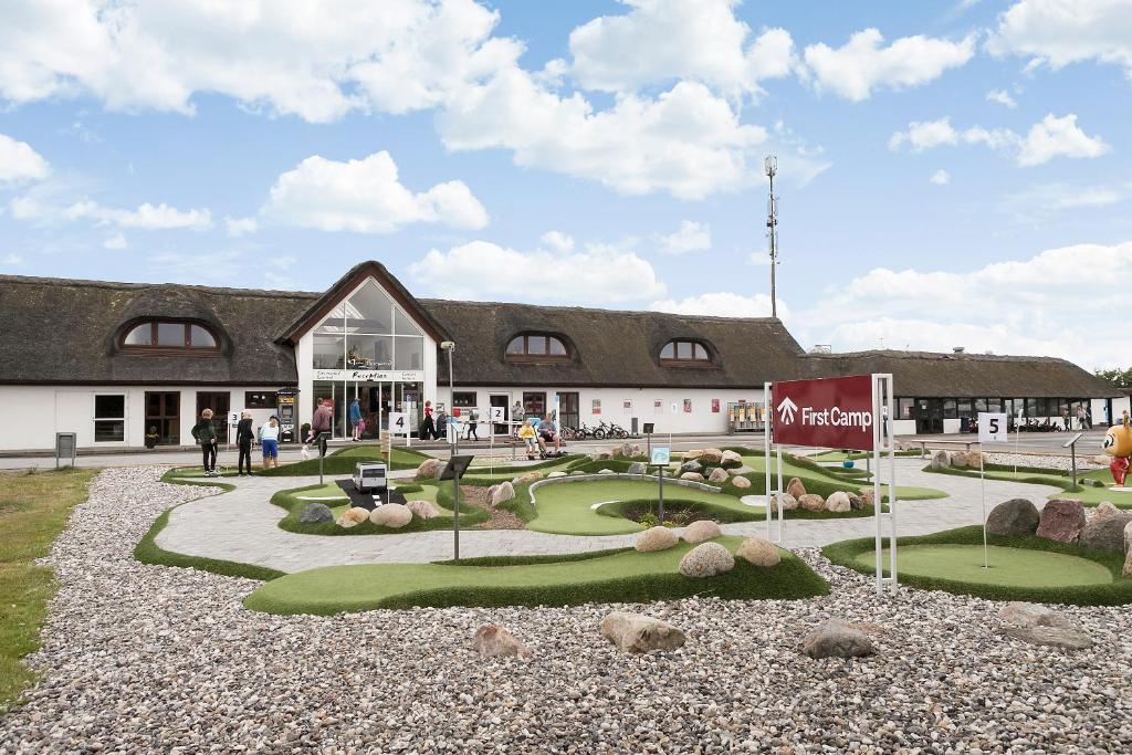 a building with a golf course in front of it at First Camp Klim Strand - Nordvestkysten in Fjerritslev