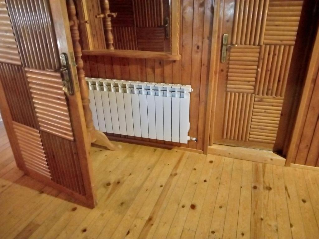 Habitación con suelo de madera y radiador blanco. en حاتم للعقارات افران المغرب, en Ifrane