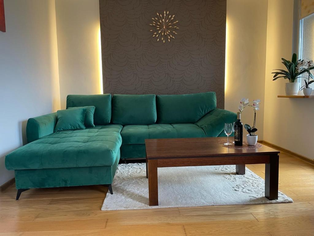 a green couch in a living room with a coffee table at Sunny Apartament in Reda