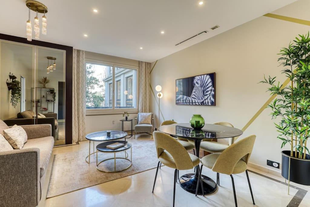 uma sala de estar com um sofá, uma mesa e cadeiras em Montaigne Executive Suite em Paris