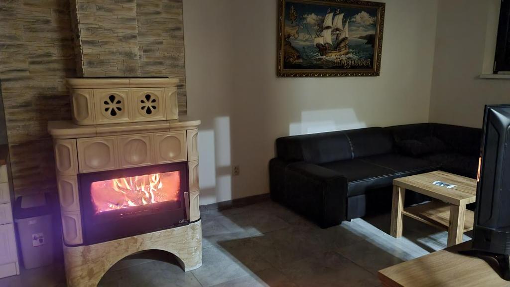ein Wohnzimmer mit einem Kamin und einem Sofa in der Unterkunft Apartmány Sebastián in Pribylina