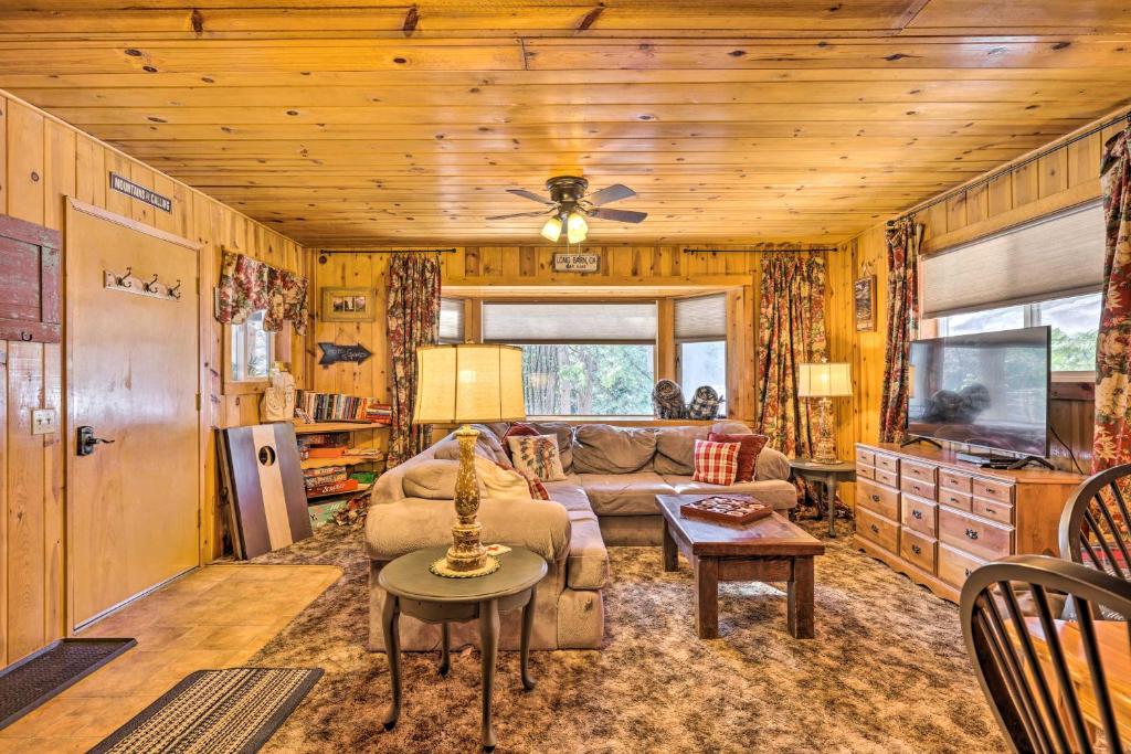 ein Wohnzimmer mit einem Sofa und einem TV in der Unterkunft California Retreat with Deck, Fire Pit and Grill! in Long Barn