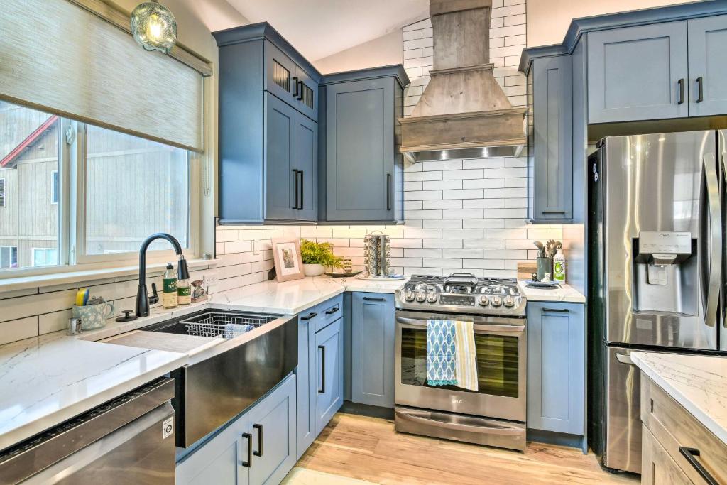uma cozinha com armários azuis e electrodomésticos de aço inoxidável em Anchorage Apartment with a View about 3 Mi to Airport em Anchorage