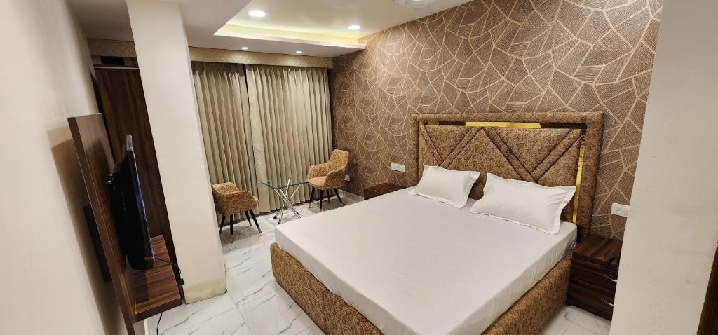 a bedroom with a bed with white sheets and pillows at OVEL HOTEL (SKY VIEW) in Ludhiana