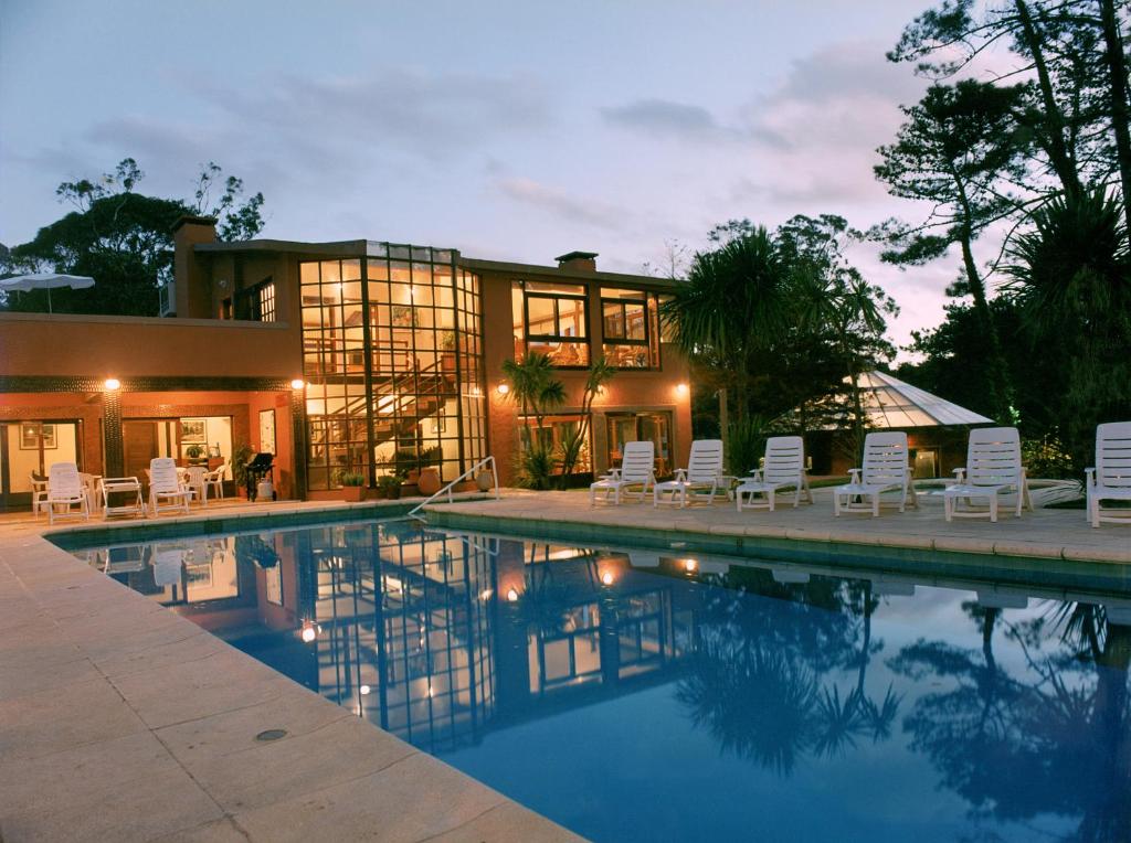 a house with a swimming pool in front of a house at Rincon del Este Resort in Punta del Este