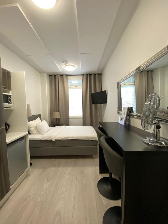 een hotelkamer met een bed, een bureau en een slaapkamer bij Akselin & Elinan Asema Oy in Pyhäntä