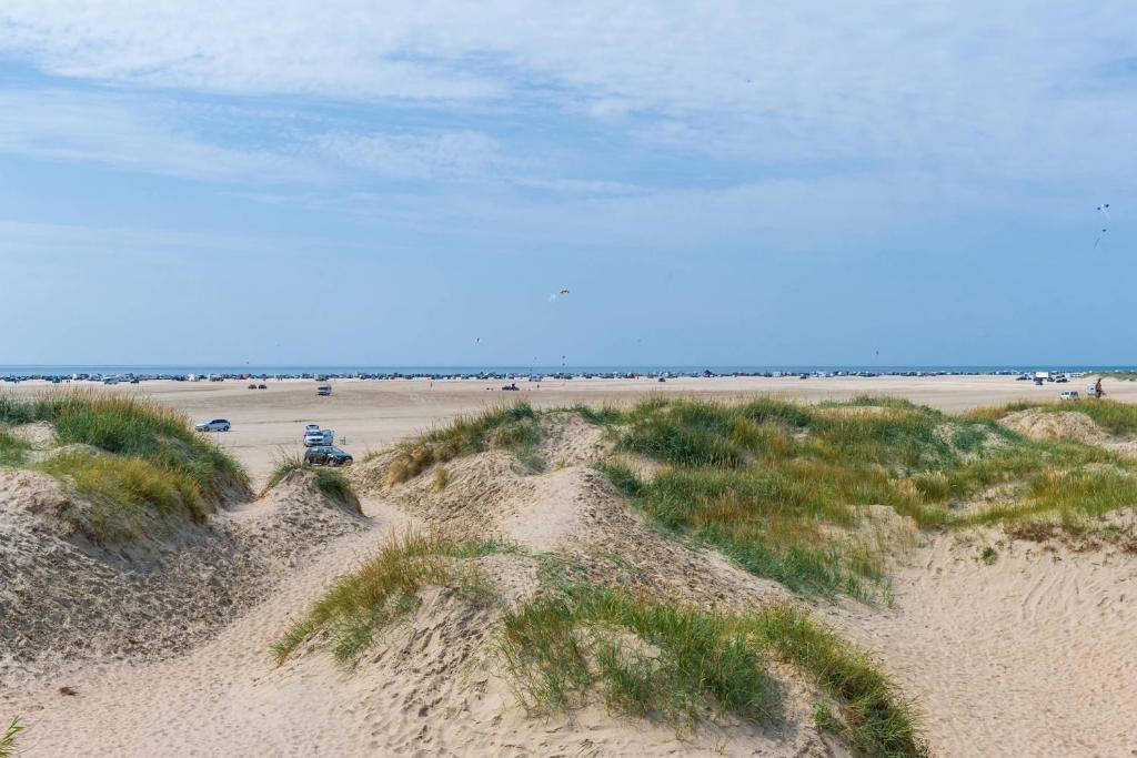 a beach with a car parked on the sand at First Camp Lakolk Strand Camping in Lakolk