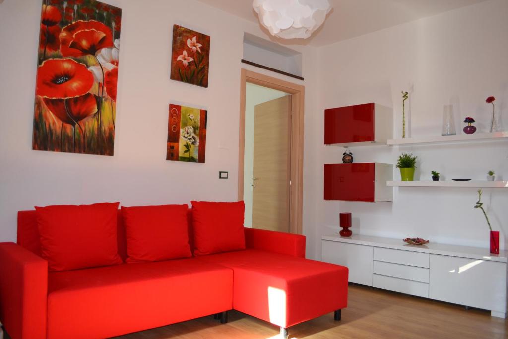 a living room with a red couch and red cabinets at Casa Colorata in Palermo