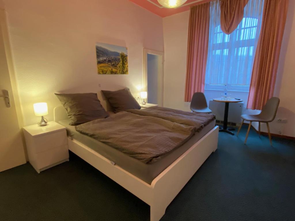 a bedroom with a bed and a table and a window at Weinzeit Kröv in Kröv