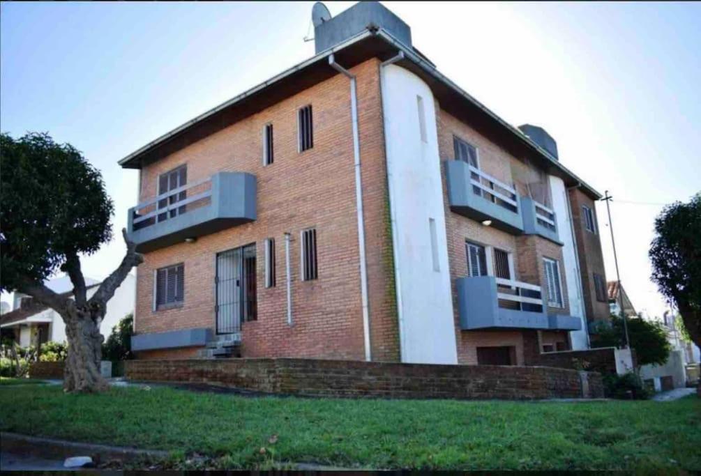 un gran edificio de ladrillo con balcones en un lateral. en Imperdible casa con vista al mar, parrilla, hogar y Netflix en Mar del Plata