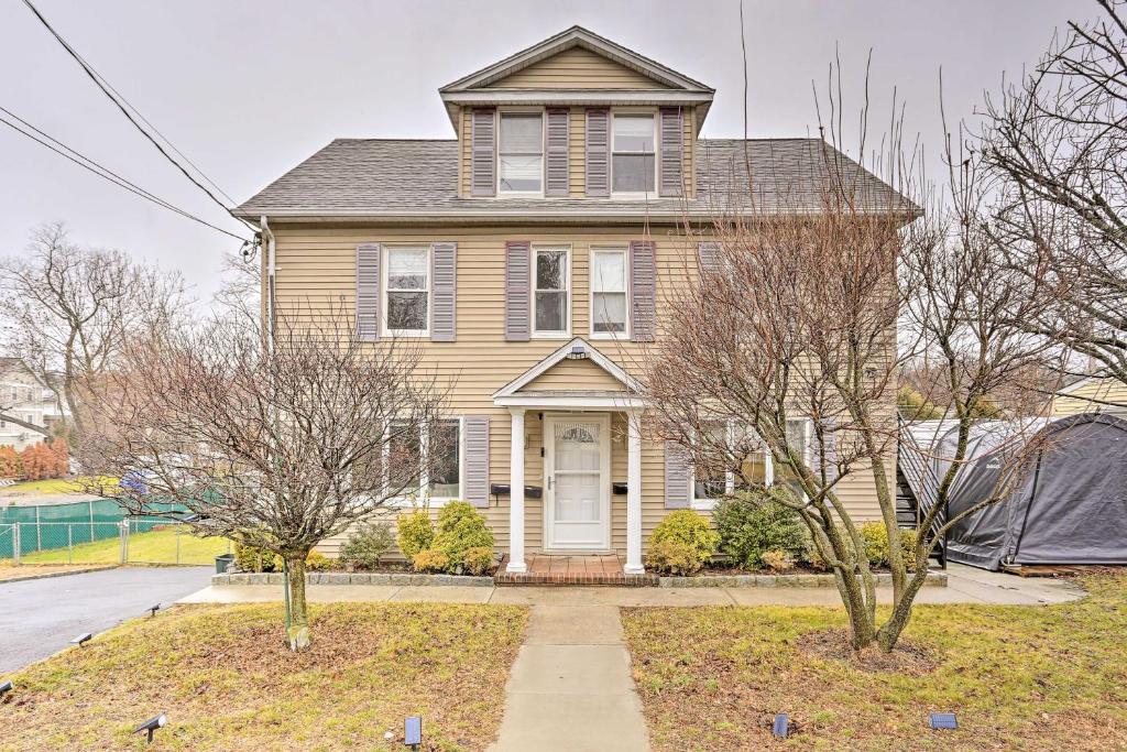 a yellow house with a white door and two trees at Charming Mamaroneck Home about 22 Mi to Manhattan 