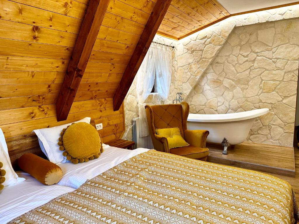 a bedroom with a bed and a tub in a room at Boutique Villa Pearl of Plitvice, Plitvice Lakes in Plitvica Selo