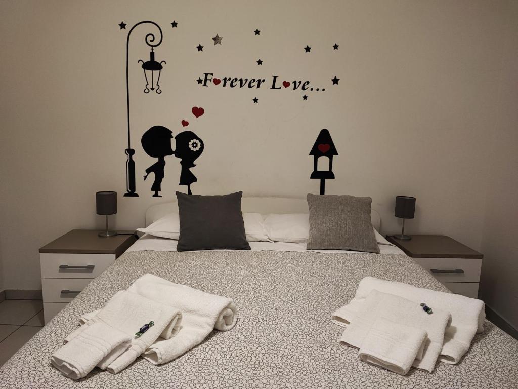 a bedroom with a bed with the words forever love at mungiBEDdu Apartment in Catania