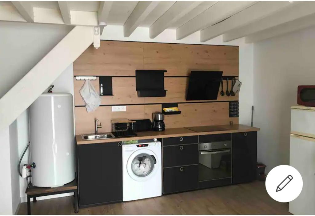 a kitchen with a washing machine in a room at Logement avec tranquillité absolue in Hamel ès Ronches