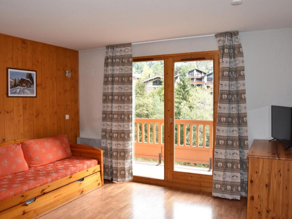 - un salon avec un canapé et une porte coulissante en verre dans l'établissement Appartement Pralognan-la-Vanoise, 3 pièces, 4 personnes - FR-1-464-157, à Pralognan-la-Vanoise