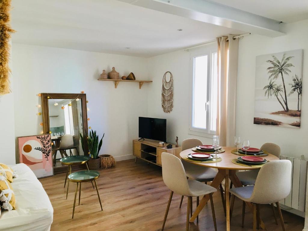 a living room with a dining room table and chairs at Chez Louise et Lucette in Sanary-sur-Mer