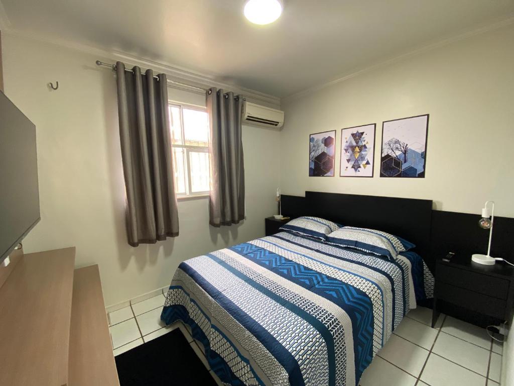 1 dormitorio con 1 cama con manta azul y blanca en Apto refugio 304 em Sao Luis - MA, en São Luís