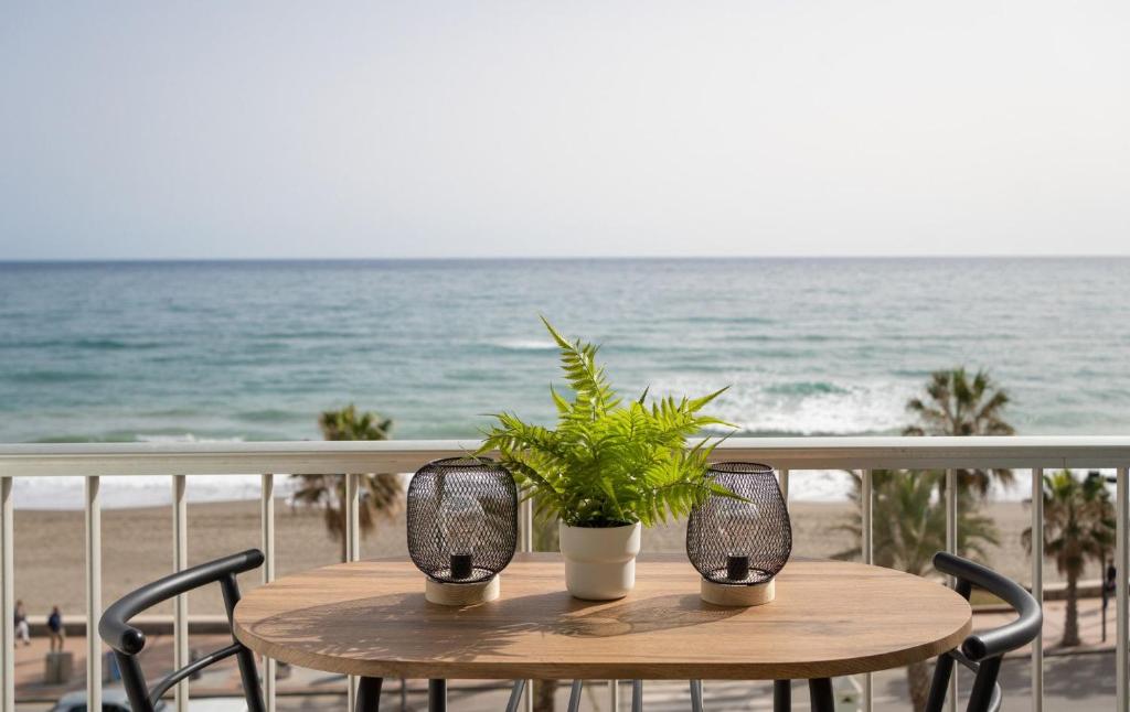 un tavolo in legno con piante su un balcone con vista sulla spiaggia di Luxury Beach home a Fuengirola