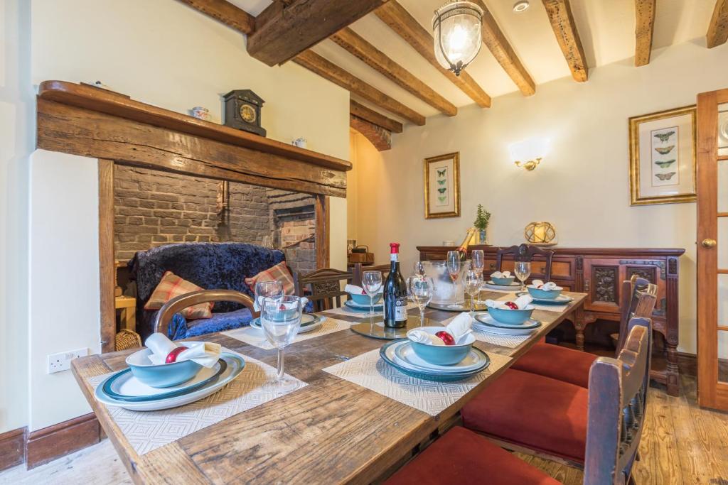 een eetkamer met een tafel en een open haard bij Wisteria House, 6 beds Central Uckfield East Sussex in Uckfield