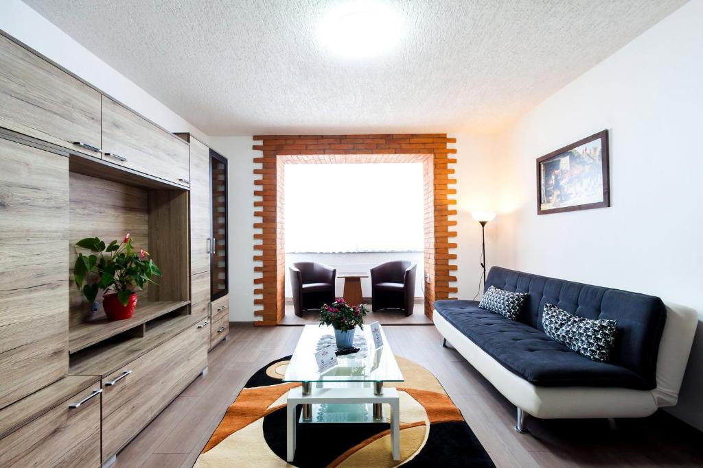 ein Wohnzimmer mit einem Sofa und einem Tisch in der Unterkunft Mónika Apartman in Remetea