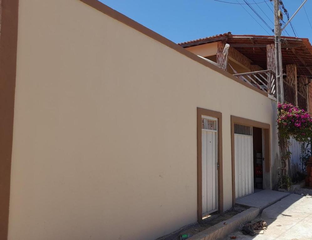 Una casa blanca con una puerta en el costado. en Casa L&A en Aracati