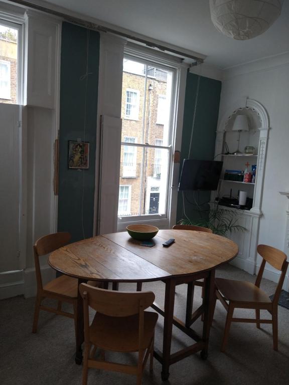 a dining room with a wooden table and chairs at Central London flat. Georgian Terrace. Bright. in London